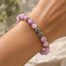 Load image into Gallery viewer, Person wearing MysticFlavia Kunzite bracelet with carved silver beads on wrist

