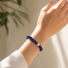 Load image into Gallery viewer, Lapis lazuli double flat silver bead bracelet worn on wrist with plant shadow and white background


