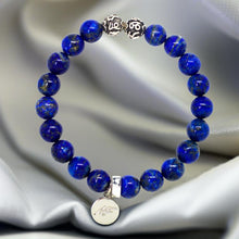 Load image into Gallery viewer, Lapis lazuli super silver bead bracelet 8mm on grey fabric with engraved silver beads and brand charm pendant

