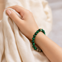 Load image into Gallery viewer, Malachite stone 925 sterling silver bead bracelet worn on wrist against beige fabric with engraved silver beads visible

