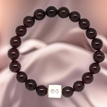Load image into Gallery viewer, Natural Garnet Birthstone Infinity Silver Bead Bracelet 8mm displayed on a soft fabric background with deep red gemstone beads
