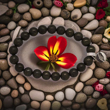 Load image into Gallery viewer, Pyrite flat silver beads bracelet with MF charm, flat lay on pebbles and flower lifestyle shot
