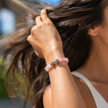 Load image into Gallery viewer, Woman wearing soft pink bead bracelet with silver detailing in outdoor sunlight

