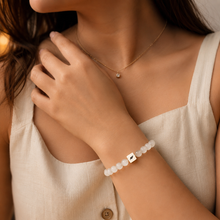 Load image into Gallery viewer, Natural selenite bracelet with 925 sterling silver brand tag worn on wrist, styled with delicate necklace, lifestyle shot


