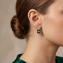 Load image into Gallery viewer, Black rectangular floral drop earrings with star design worn on a model
