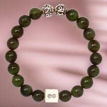 Load image into Gallery viewer, Jade bracelet flat lay showing round beads and two carved silver spacer beads

