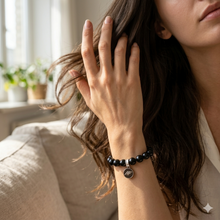 Load image into Gallery viewer, Black tourmaline flat silver beads bracelet with 925 sterling silver charm on wrist, indoor shot
