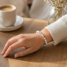 Load image into Gallery viewer, Woman wearing white howlite double silver bead bracelet on wrist, cafe table lifestyle shot

