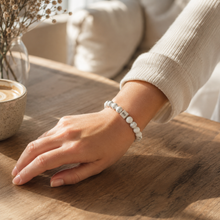 Load image into Gallery viewer, Woman wearing white howlite infinity silver bead bracelet on wrist, warm cafe lifestyle shot

