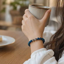 Load image into Gallery viewer, Woman wearing blue tiger eye silver beads bracelet on wrist while holding a cup
