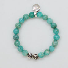 Load image into Gallery viewer, MysticFlavia amazonite bracelet with teal beads, carved silver bead at bottom and round silver brand charm at top, white background

