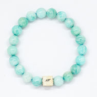 Amazonite infinity silver bead bracelet with soft teal-green round beads and square silver brand tag at bottom, white background
