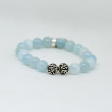Load image into Gallery viewer, Close-up of aquamarine birthstone bracelet showing two carved 925 sterling silver beads and pale blue round beads, white background

