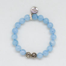 Load image into Gallery viewer, MysticFlavia Aquamarine Birthstone bracelet with vivid blue beads, carved silver beads at bottom and round brand charm at top, white background

