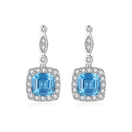 Sapphire Blue Dangling Silver Earrings with Halo Design | MysticFlavia