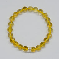 Citrine bracelet with round golden gemstone beads and silver accent bead on a white background