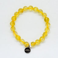 Citrine bracelet with flat yellow gemstone beads, silver spacer and MysticFlavia charm on white background