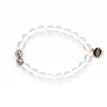 Load image into Gallery viewer, Clear quartz bracelet with 925 sterling silver patterned beads and MysticFlavia logo charm, side angle flat lay

