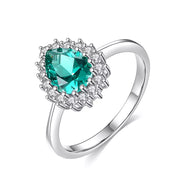 Emerald silver ring with oval green gemstone and diamond halo