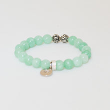 Load image into Gallery viewer, Jade bracelet showing two carved silver spacer beads between rows of green beads
