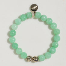 Load image into Gallery viewer, Jade bracelet flat lay showing silver charm engraved with logo above green beads

