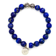 MysticFlavia lapis lazuli bracelet 8mm flat view with two engraved silver accent beads and round brand charm on white background
