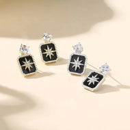Black rectangular floral drop earrings with sparkling stone border on white background