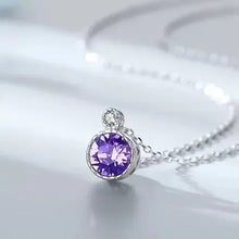 Load image into Gallery viewer, Purple crystal circle pendant on a silver chain resting on white satin fabric
