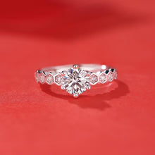 Load image into Gallery viewer, Round moissanite silver ring displayed on a red background

