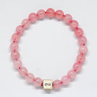 Rose quartz bracelet with round pink beads and infinity charm on white background by MysticFlavia