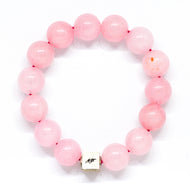 Rose quartz bracelet with round 12mm beads and silver cube charm on white background