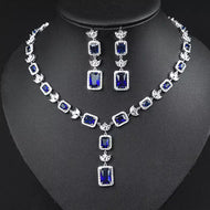 Blue gemstone silver necklace set with matching drop earrings displayed on a black jewelry bust