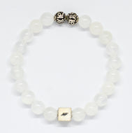 MysticFlavia selenite bracelet with translucent white round beads, two carved silver beads on top and square brand tag, white background
