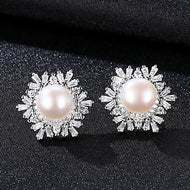 Snowflake pearl pavé zircon silver earrings displayed on a dark textured background
