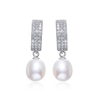 Silver pearl drop earrings with round white pearls displayed on a white background.