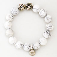 MysticFlavia white howlite bracelet 12mm with ornate silver accent beads and brand charm on white background