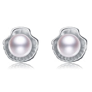 White pearl shell-shaped silver stud earrings on a white background